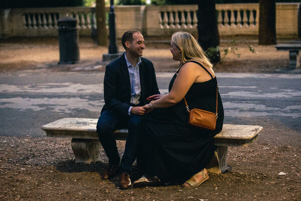 newly-engaged couple sitting on a bench at the Pincio Gardens after sunset