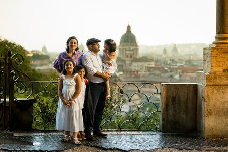 Family posing on the Terrazza Belvedere after a storm during their surprise proposal photo session in Rome