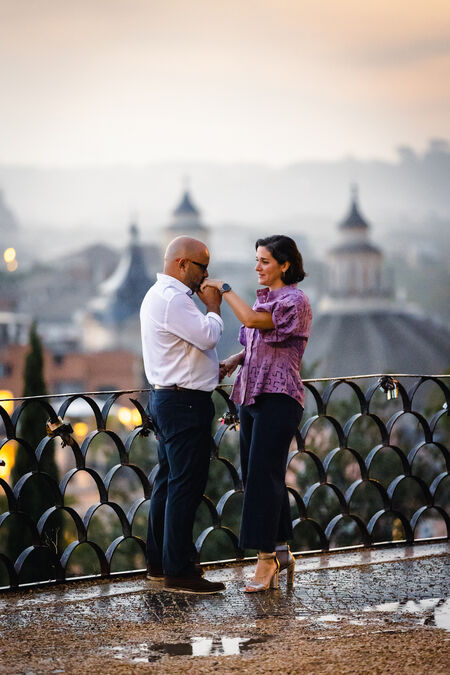 Newly-engaged husband kissing his future wife during their surprise wedding proposal photo shoot on the Terrazza Belvedere in Rome