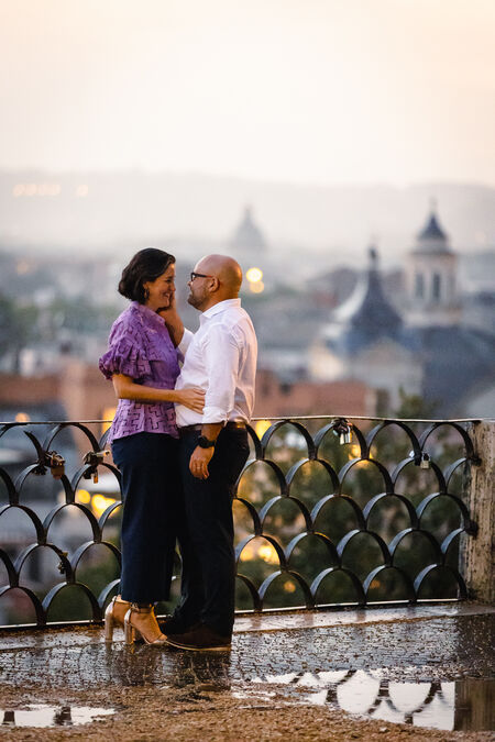 Newly-engaged couple smiling at each other during their surprise marriage proposal photo shoot on the Terrazza Belvedere in Rome