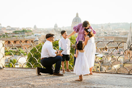 Father proposes to the mother of their 3 kids on the Terrazza Belvedere at sunset in Rome