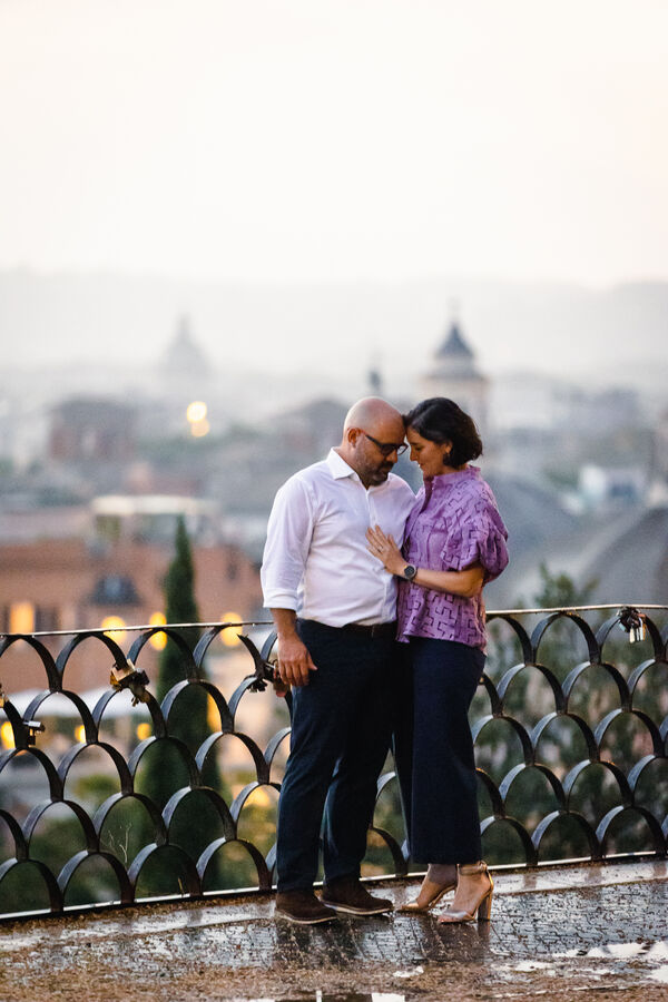 Intimate moment of a newly-engaged couple on the Terrazza Belvedere in Rome just after a rain storm