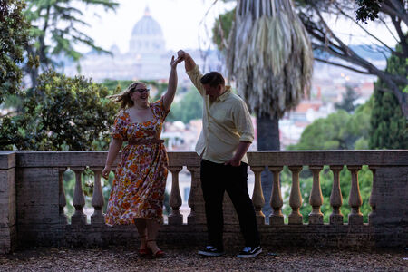 Newly-engaged couple dancing with joy during their surprise proposal photo shoot on the Pincian Hill in Rome