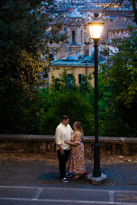 Newly-engaged couple holding each other in Rome at dusk
