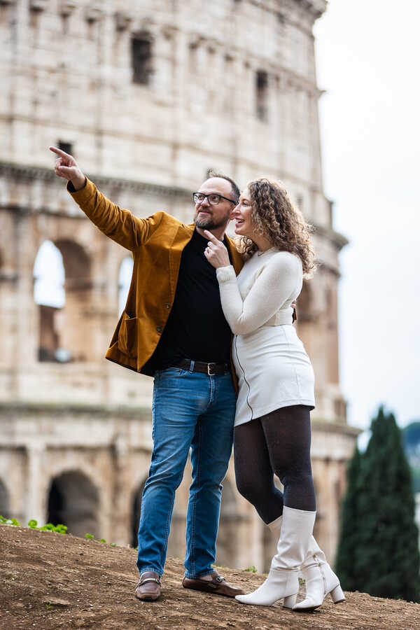 Newly-engaged couple holding each other with the Colosseum in the background