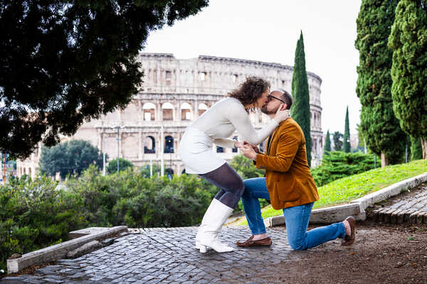 Newly-engaged couple kissing during their surprise wedding proposal in Rome