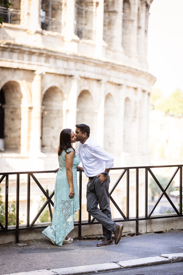 Newly-engaged couple kissing with the Colosseum in the background