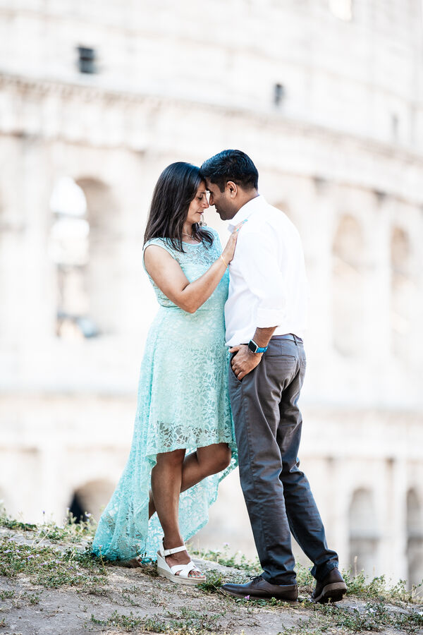 Newly-engaged couple holding each other with the Colosseum in the background