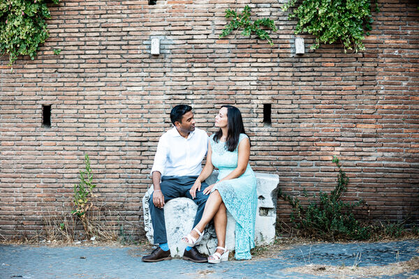 Newly-engaged couple sitting on a stone on the Capitoline Hill in Rome