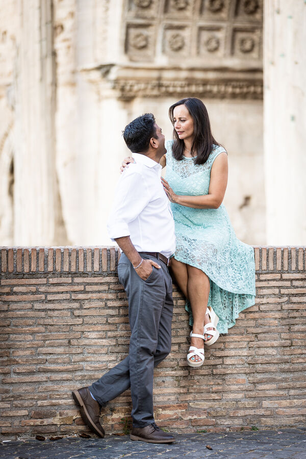 Happy newly-engaged couple in their beloved spot by the Septimius Severus Arch on the Capitoline Hill in Rome