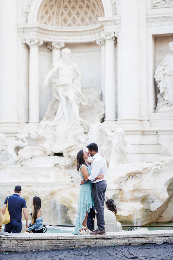 Newly-engaged couple kissing with the Trevi Fountain in the background