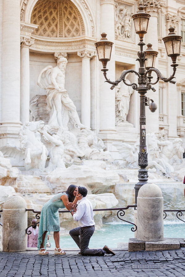 Newly-engaged couple at the Trevi Fountain Rome while kissing