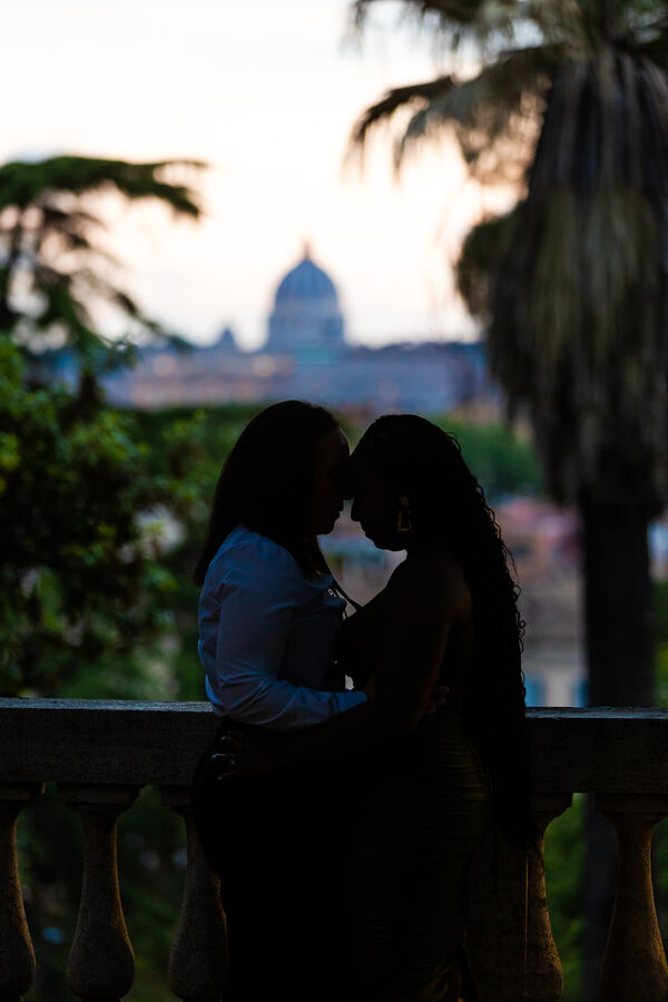 Low-key shot of lesbian couple head to head with the Vatican in the background in the blue hour