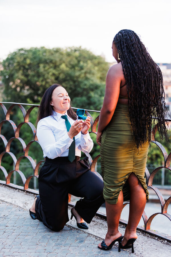 Lesbian couple during their surprise wedding proposal at sunset on the Terrazza Belvedere in Rome
