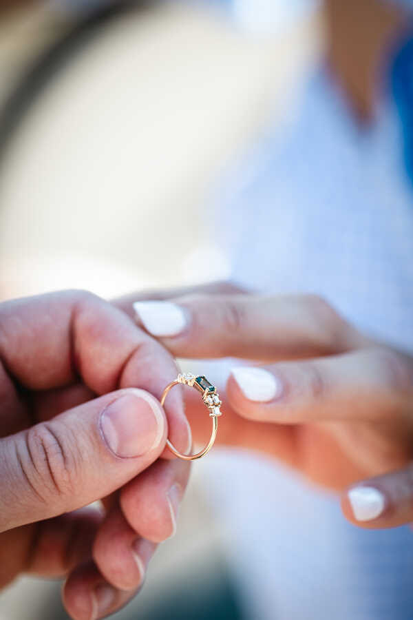 Close-up of the engaement ring being slipped on during a wedding propsoal photoshoot in Rome