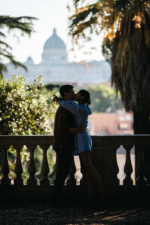 Silhouette of newly-engaged couple on the Pincian Hill kissing with the Vatican in the background