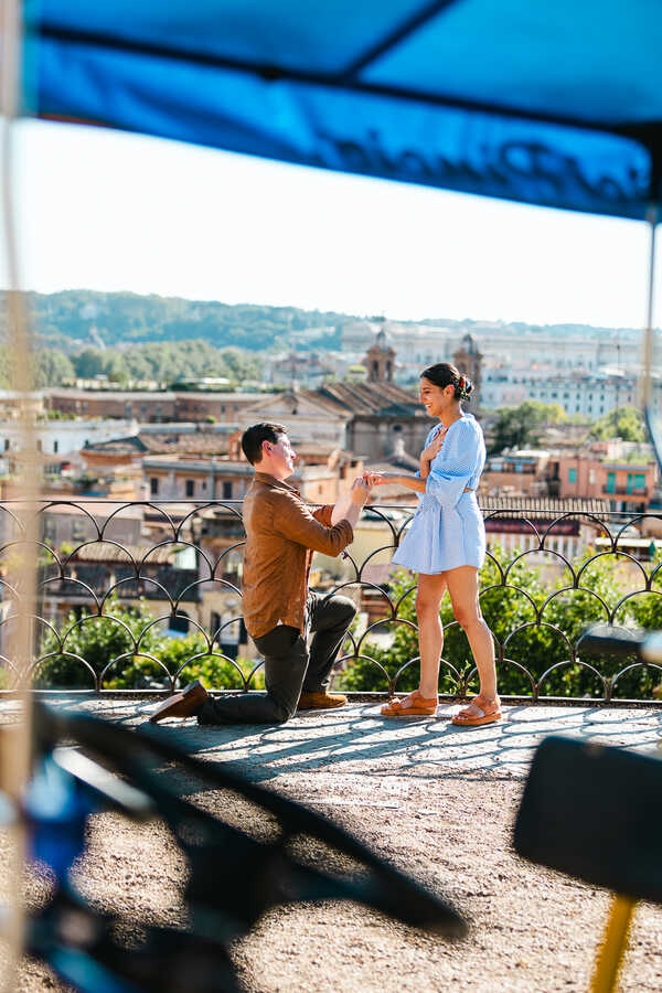 Romantic surprise wedding proposal in Rome during the slipping of the engagement ring