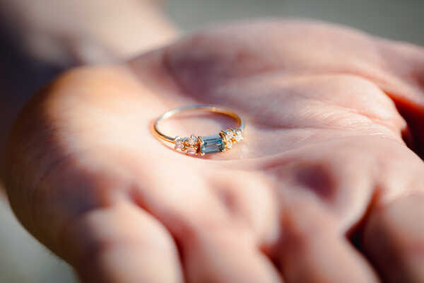 Close-up image of engagement ring being held on a hand