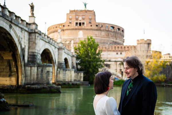 Happy newly-wed couple on the Tiber riverbank during their Sposi Novelli photoshoot in Rome