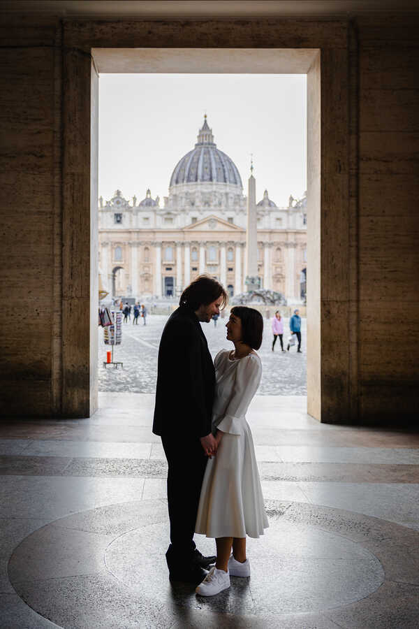 Happy  Sposi Novelli couple holding each other with the Vatican in the background