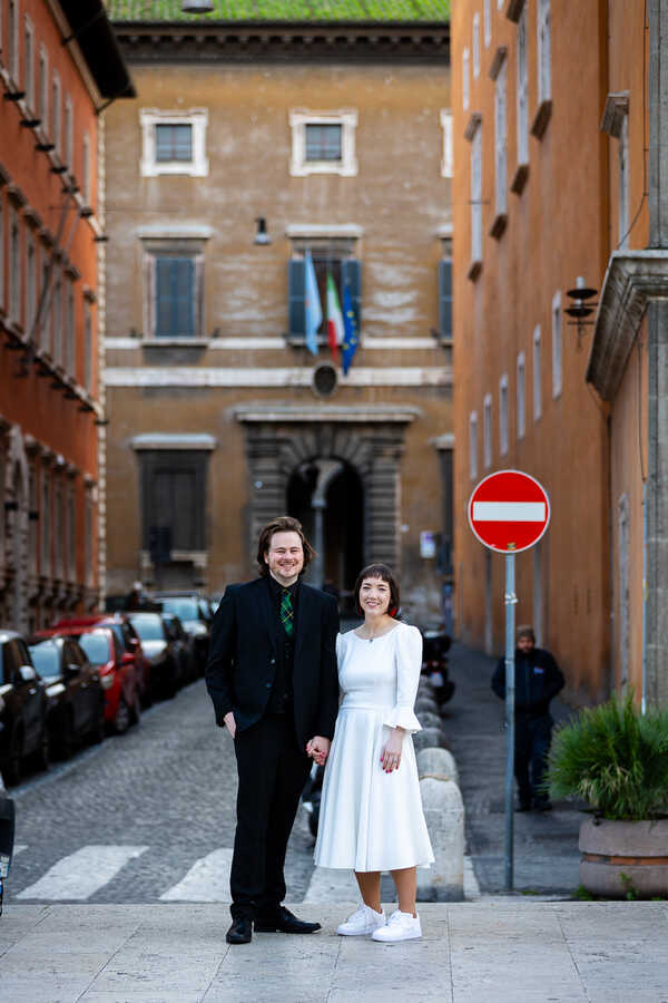 Smiling Sposi Novelli couple holding hands posing for the camera during their Sposi Novelli photo session in Rome