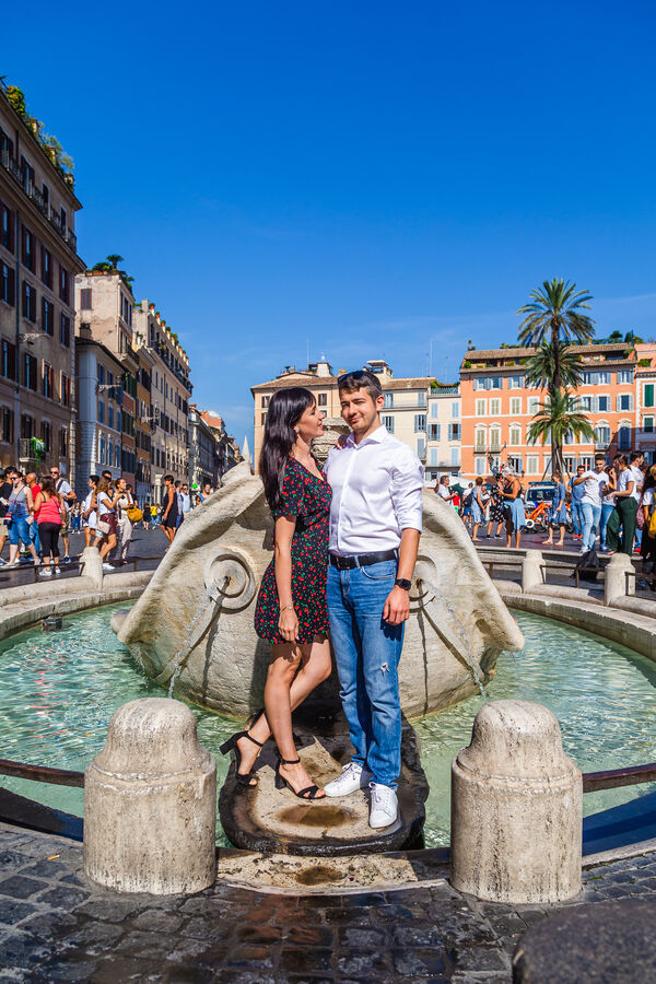 Couple kissing during their Rome vacaton photoshoot near the Barcaccia Fountain in Piazza di Spagna