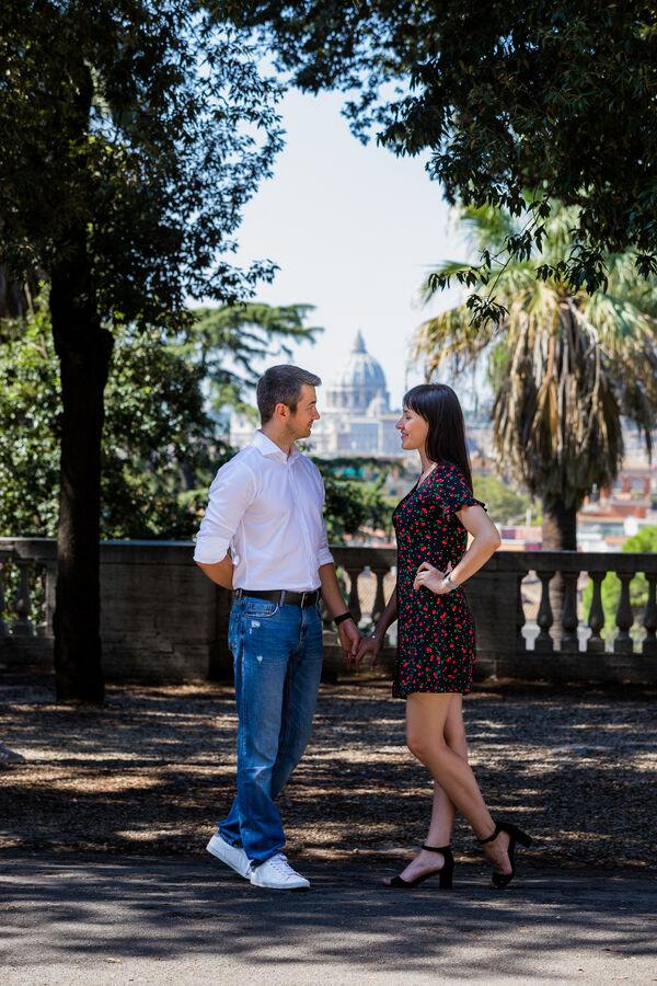 Beautiful couple at the Pincio Gardens looking at each other with the Vatican in the background